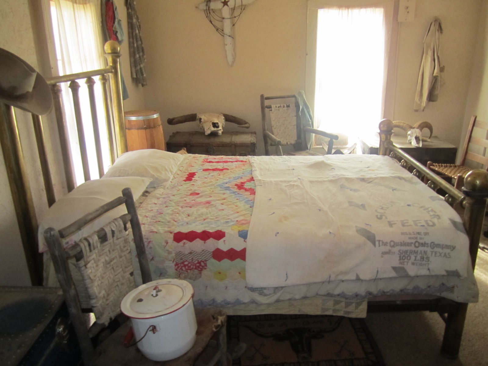A furnished bedroom at Matador Ranch with a patterned bed covering and wooden furniture