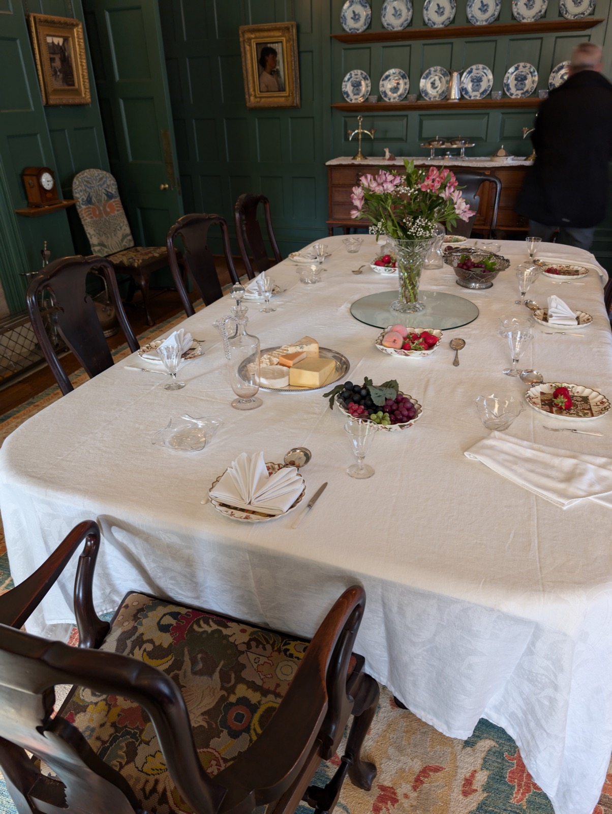 A long dining table with a white tablecloth, place settings, and flowers at Standen House